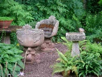 image: Quiet corner with ornate stone garden chairs and birdbath complete with thrush
